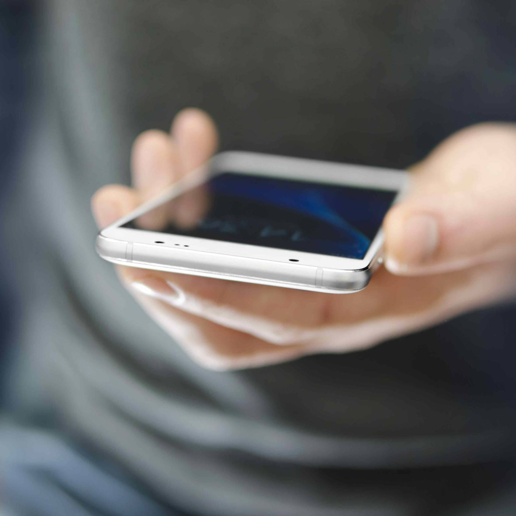 Angled view of modern phone in man hand. Modern technology concept