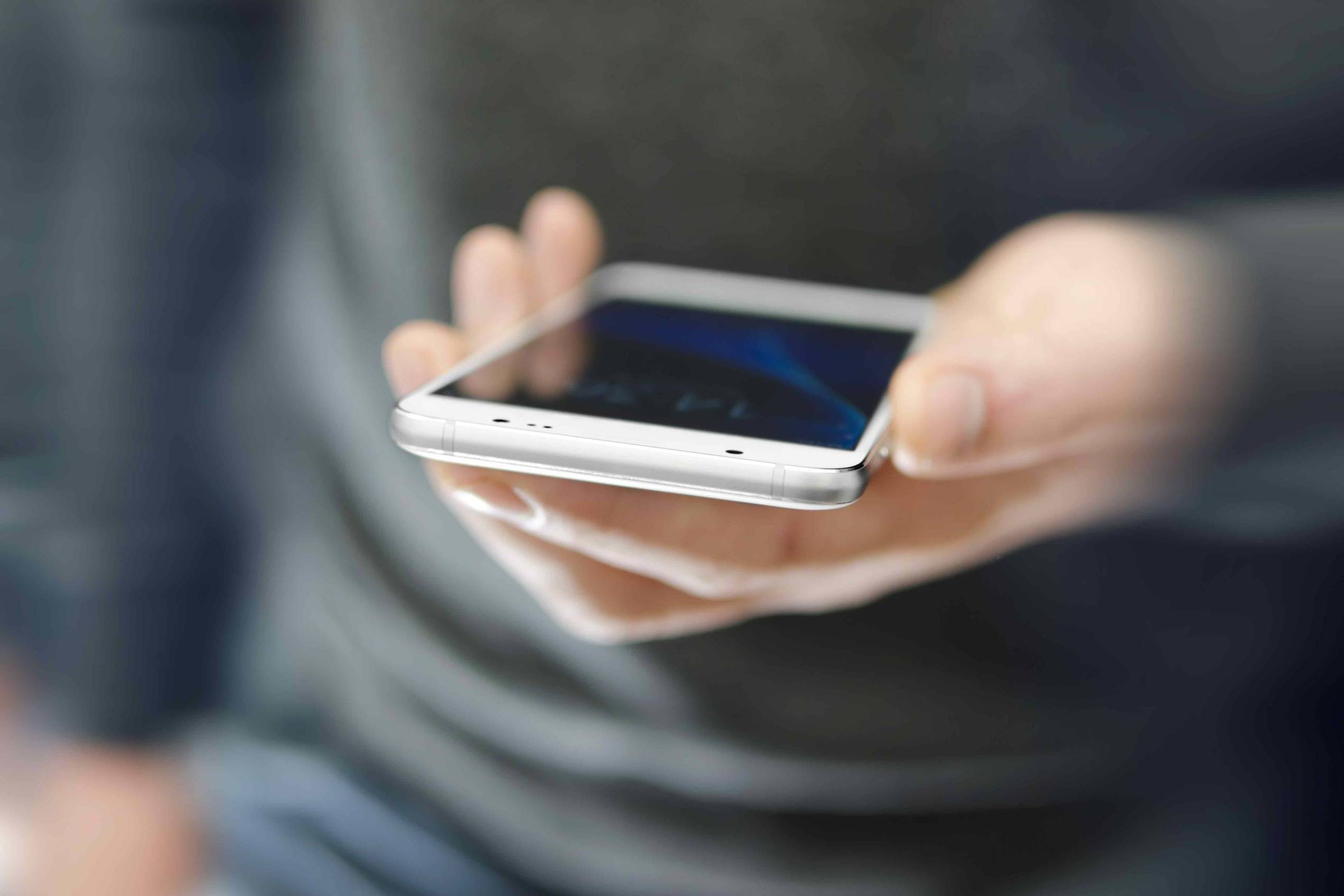 Angled view of modern phone in man hand. Modern technology concept