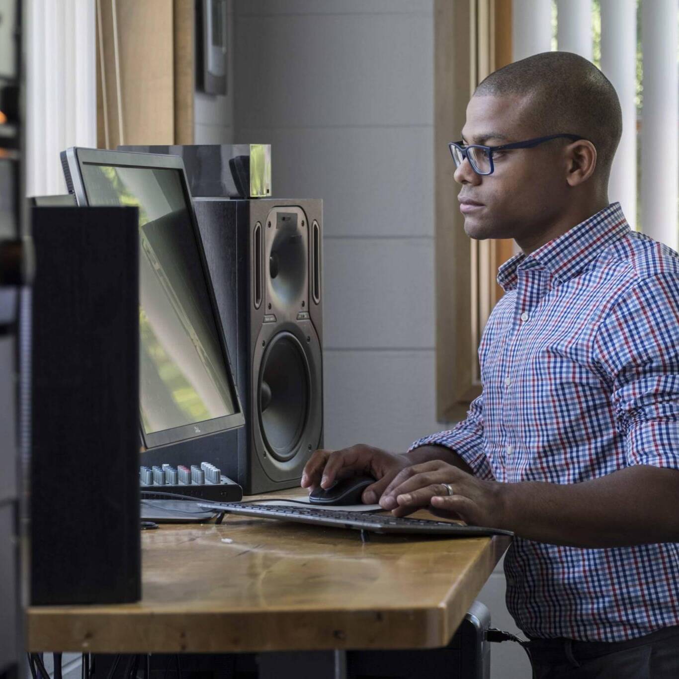 Young professional man standing at his computer in the office