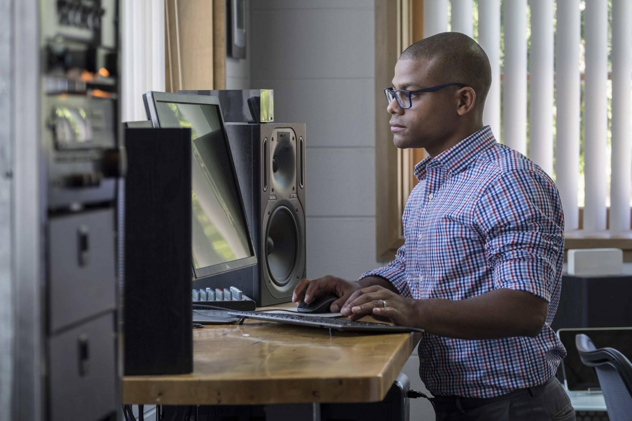 Young professional man standing at his computer in the office