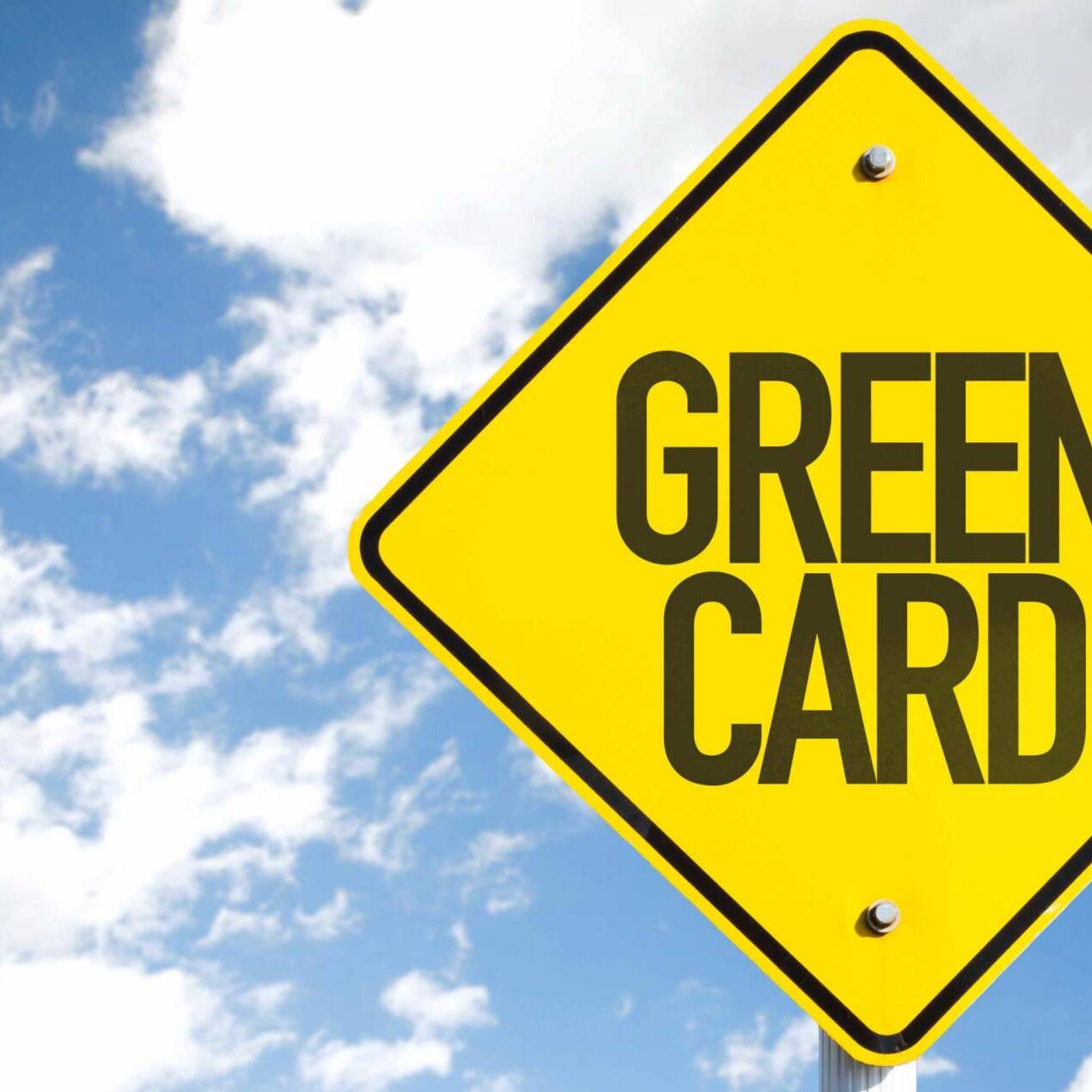 Green Card sign with sky background