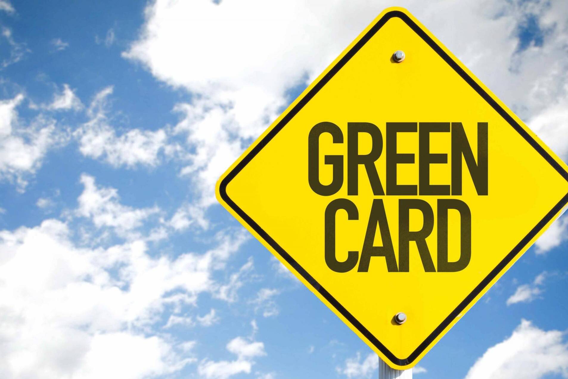 Green Card sign with sky background