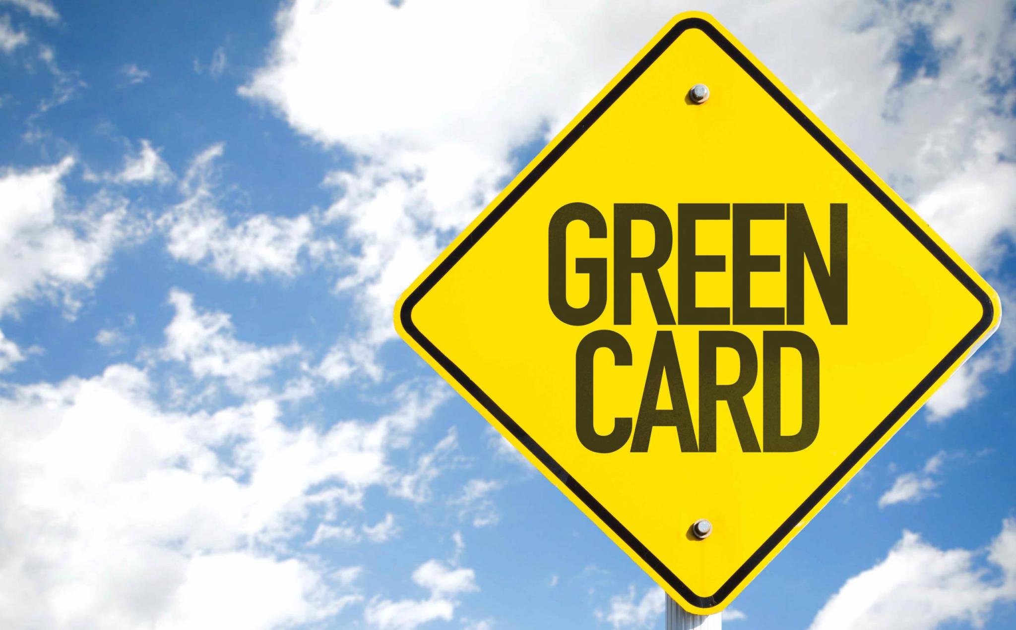 Green Card sign with sky background