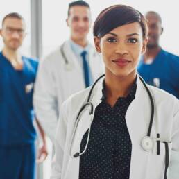 Confident female doctor in front of team