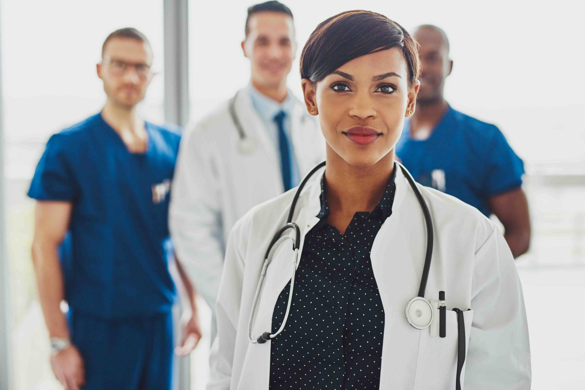 Confident female doctor in front of team