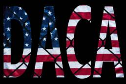 DACA bold letters with american flag and chain link fence in the background