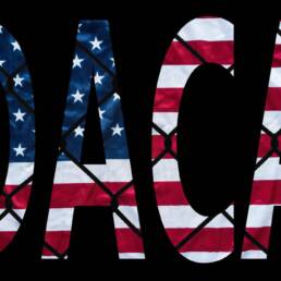 DACA bold letters with american flag and chain link fence in the background