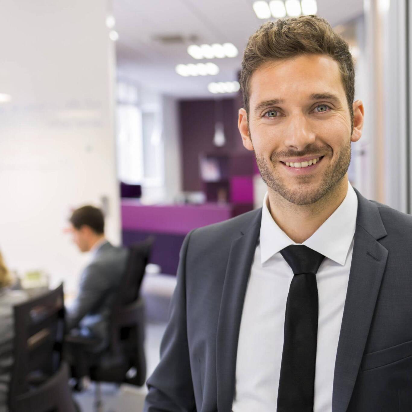 Portrait of smiling Businessman posing in modern office, lookin