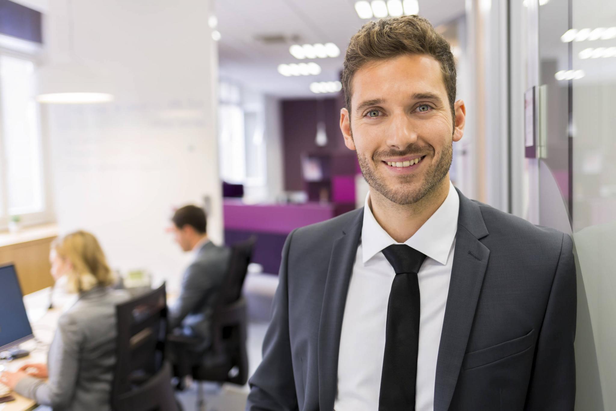 Portrait of smiling Businessman posing in modern office, lookin