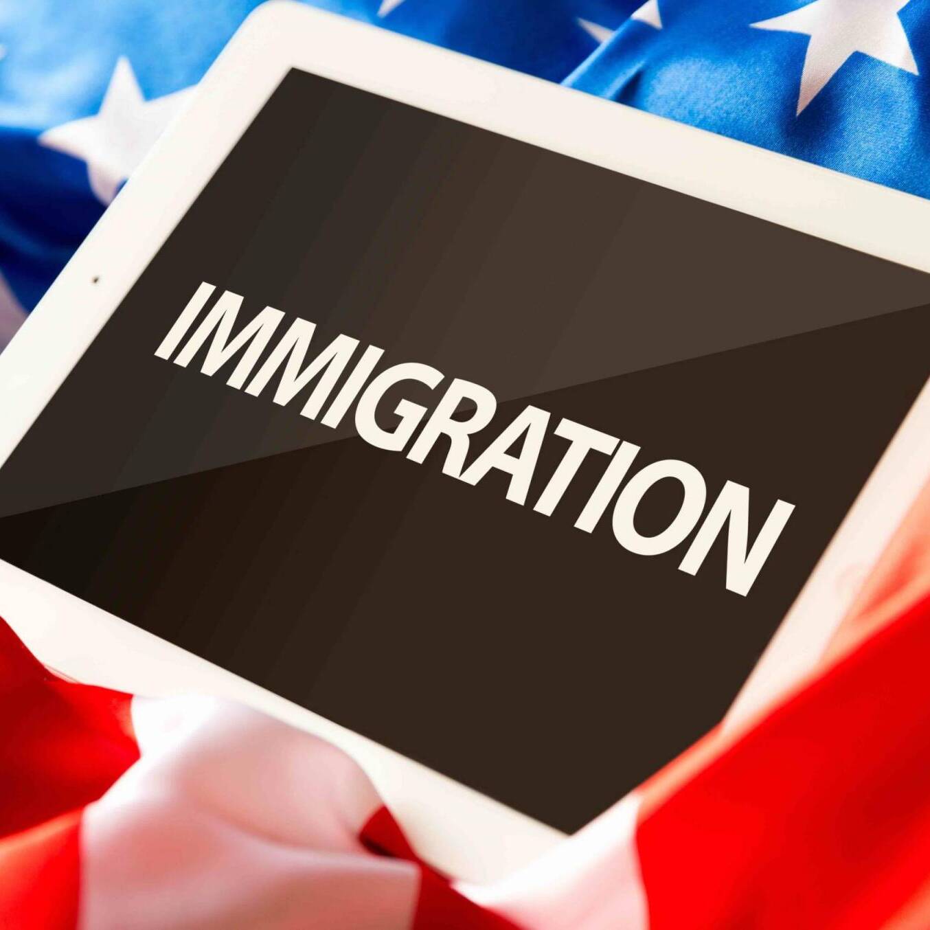 Immigration on tablet and the US flag