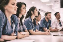 Medical students listening sitting at desk