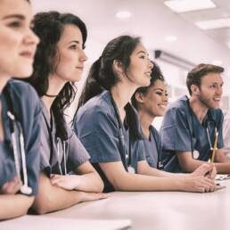 Medical students listening sitting at desk