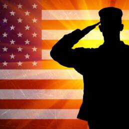 Proud saluting male army soldier on american flag background
