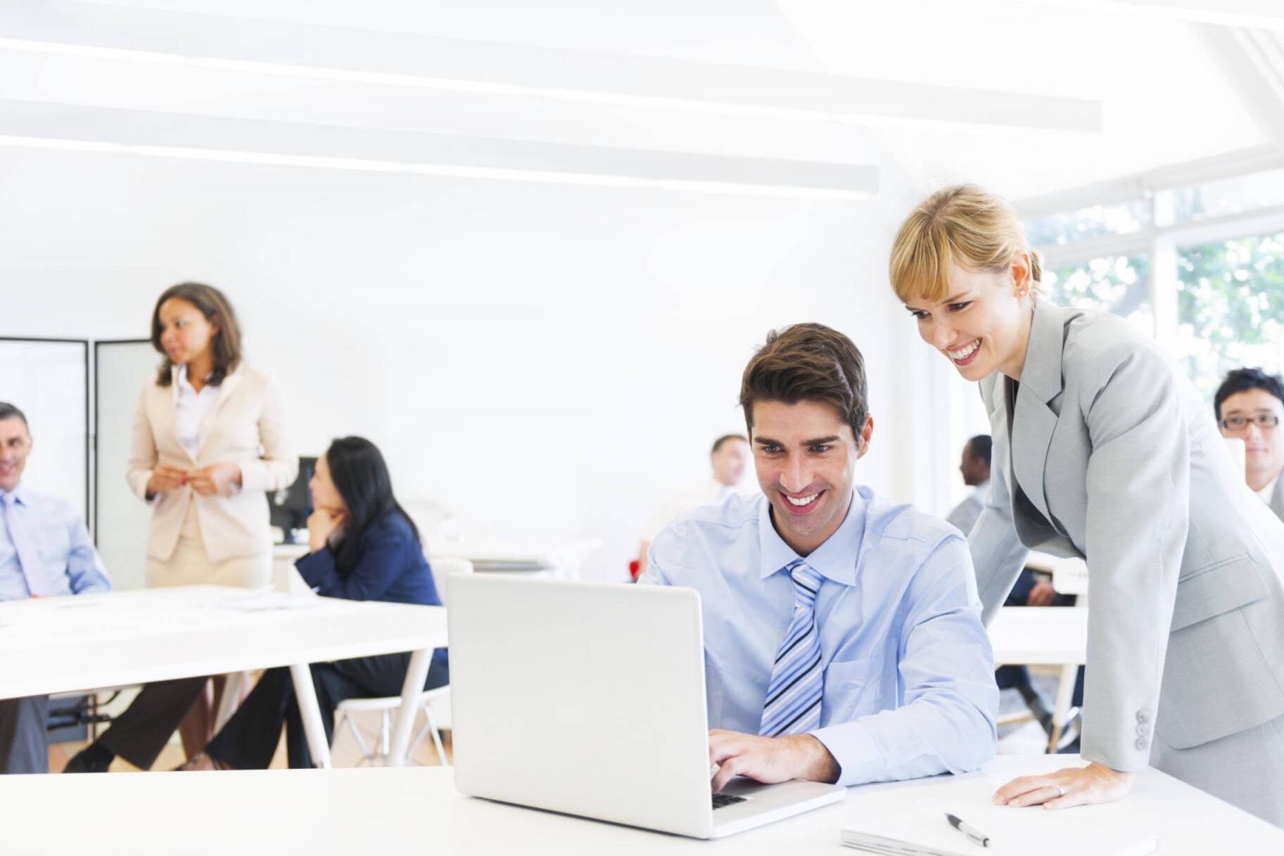 Female Manager Supervising Employee At Laptop