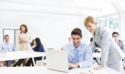 Female Manager Supervising Employee At Laptop