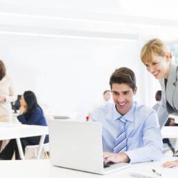 Female Manager Supervising Employee At Laptop