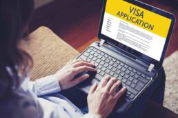 Woman doing electronic Visa Application in a laptop by internet.