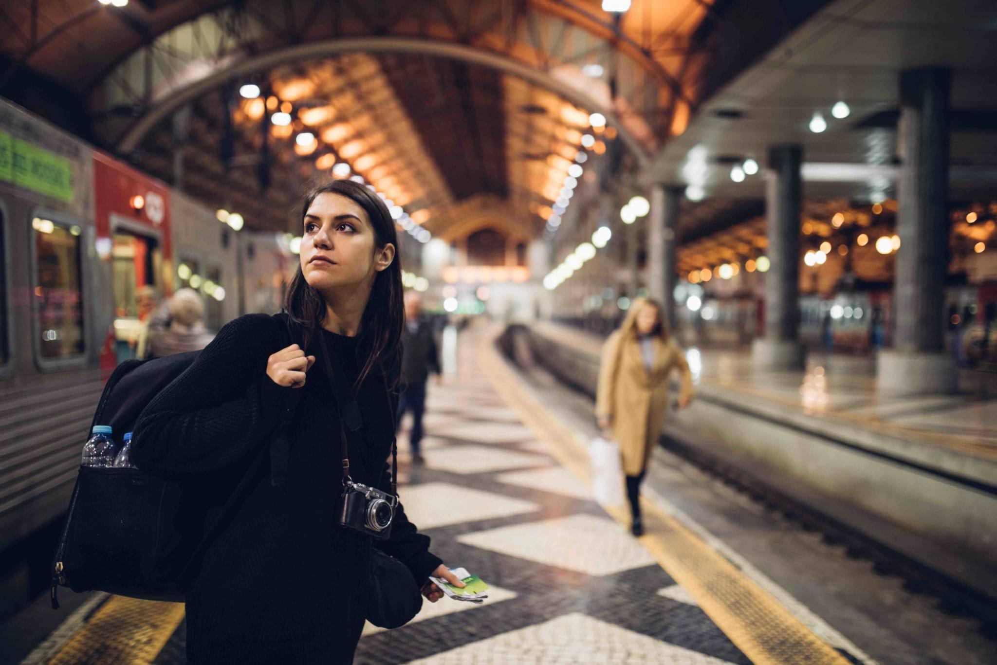 Female traveler searching for directions,waiting for the train/tram,using transportation in foreign country.Urban tourism.Low budget cheap ticket backpacking.Travel to the destination