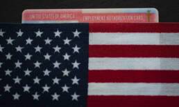 Employment authorization card under Flag of USA (United states of America). Close up.