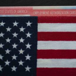 Employment authorization card under Flag of USA (United states of America). Close up.