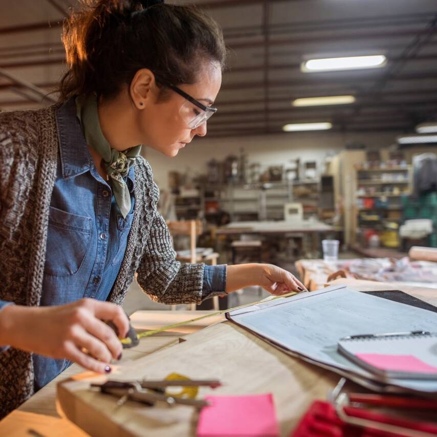 Picture of beautiful focused middle aged woman architect in her workshop working on new projects.