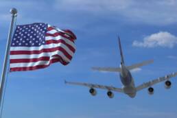 Commercial airplane landing behind waving American flag. Travel to the United States conceptual 3D rendering