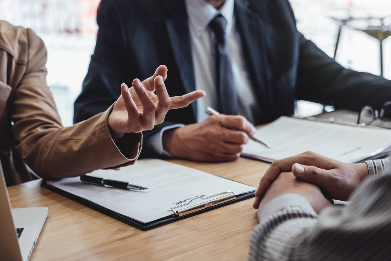 Two senior manager reading a resume during a job interview, Employer interviewing to ask young male job seeker for recruitment talking in office