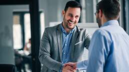 Portrait of cheerful young manager handshake with new employee.