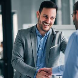 Portrait of cheerful young manager handshake with new employee.